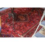 A Persian Shiraz small carpet, the dusky red ground with stylised centre medallion,