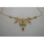 An Art Nouveau pendant necklace with foliate centrepiece set with peridot and seed pearls on fine