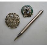 A white paste set brooch featuring basket of flowers to/w clan brooch featuring stag and green