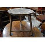 An antique walnut and elm cricket table,