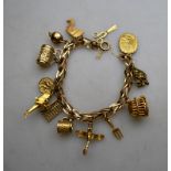 A 9ct yellow gold bracelet with bolt ring having thirteen charms attached,