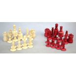 A 19th century ring-turned bone chess set with red dye, king 9.