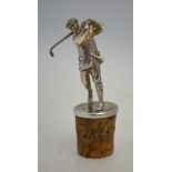 A cast silver figure of an Edwardian golfer, 17 cm high, mounted on a cork bottle-stopper,