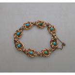 A rose gold stylised knot bracelet set with turquoise, fitted with safety catch, stamped 9ct,