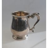 A silver baluster pint mug in the Georgian manner, with scroll handle and moulded foot-rim,