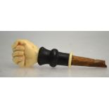 A 19th century Indian ivory parasol pommel, carved as a clench hand holding a flower, on ebony stem,