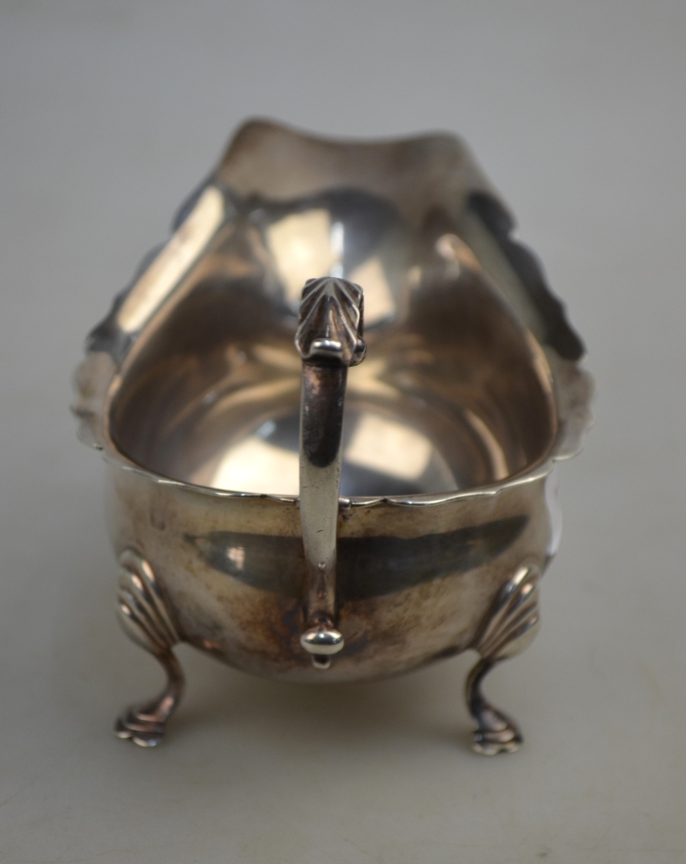 An Edwardian silver sauce boat with cut rim, scroll handle and hoof feet, Haseler Bros. - Image 4 of 4