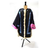 A black-ground silk coat with folded pink-ground cuffs decorated with flower arrangements;