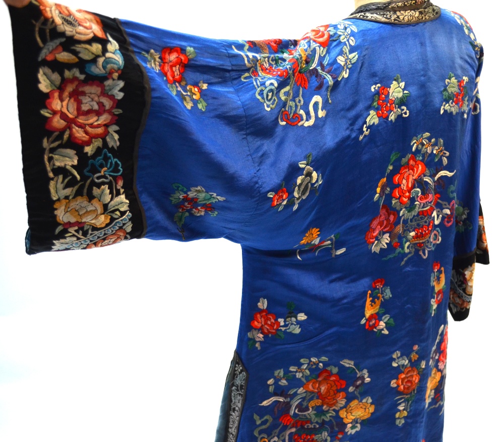 A blue ground Chinese silk coat, decorated with floral designs; the black ground sleeves,