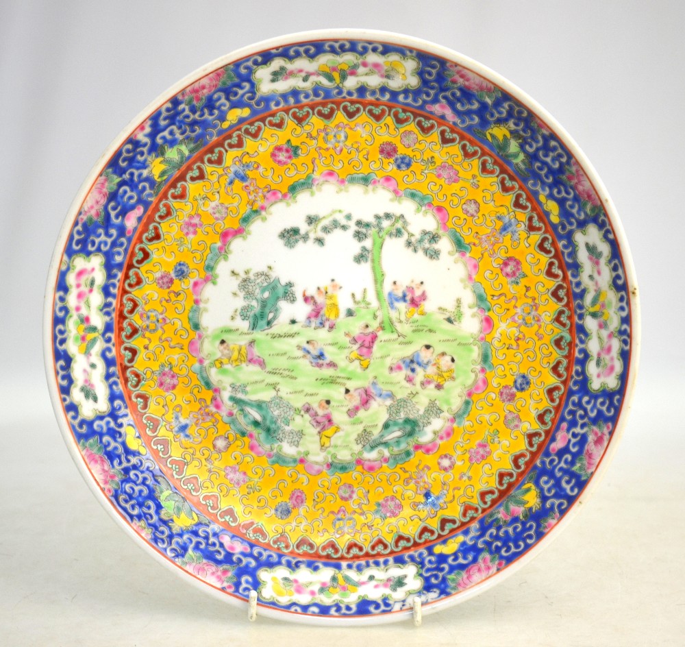 A famille rose dish, decorated with a central design of Manchu/Chinese boys at play; 29.