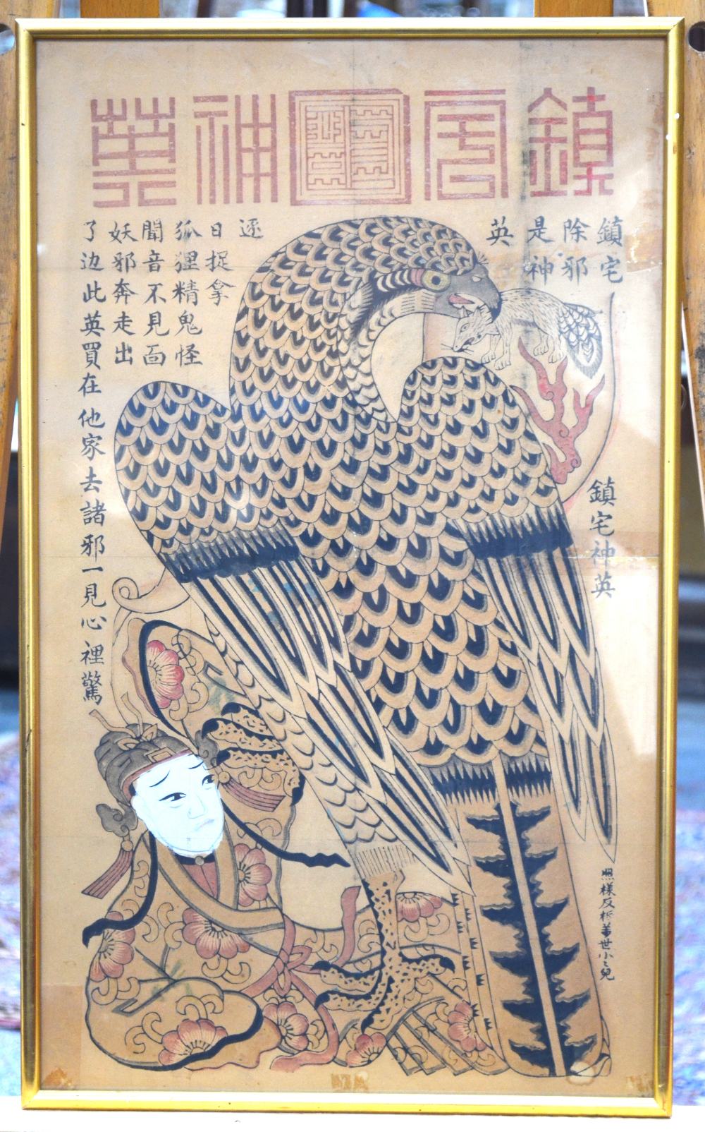 A Chinese picture of a bird-of-prey holding a small mammal with its beak whilst holding down a