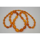 An amber necklace with 47 beads, variously sized, about 41cm long when hanging, approx. 60g all-in.