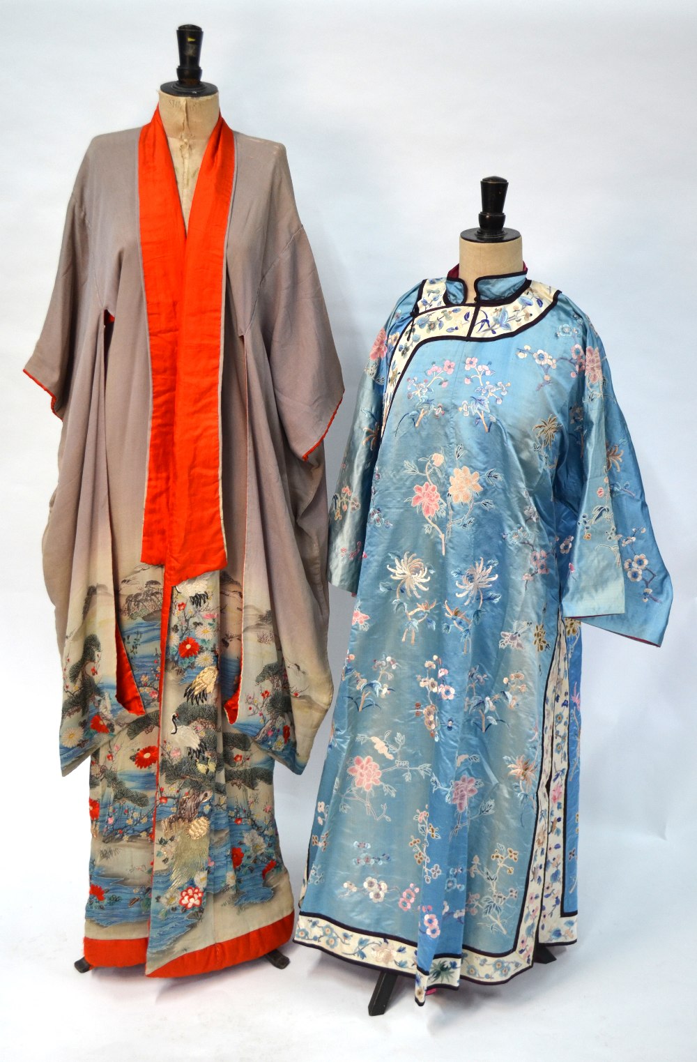 A Chinese blue silk robe embroidered with flowering prunus, japonica and tree peonies,