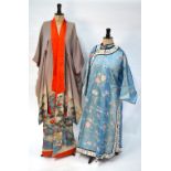 A Chinese blue silk robe embroidered with flowering prunus, japonica and tree peonies,