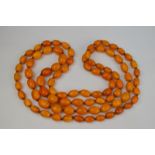 AMENDED ESTIMATE - An amber necklace comprising 88 beads, length when hanging about 63 cm, approx.