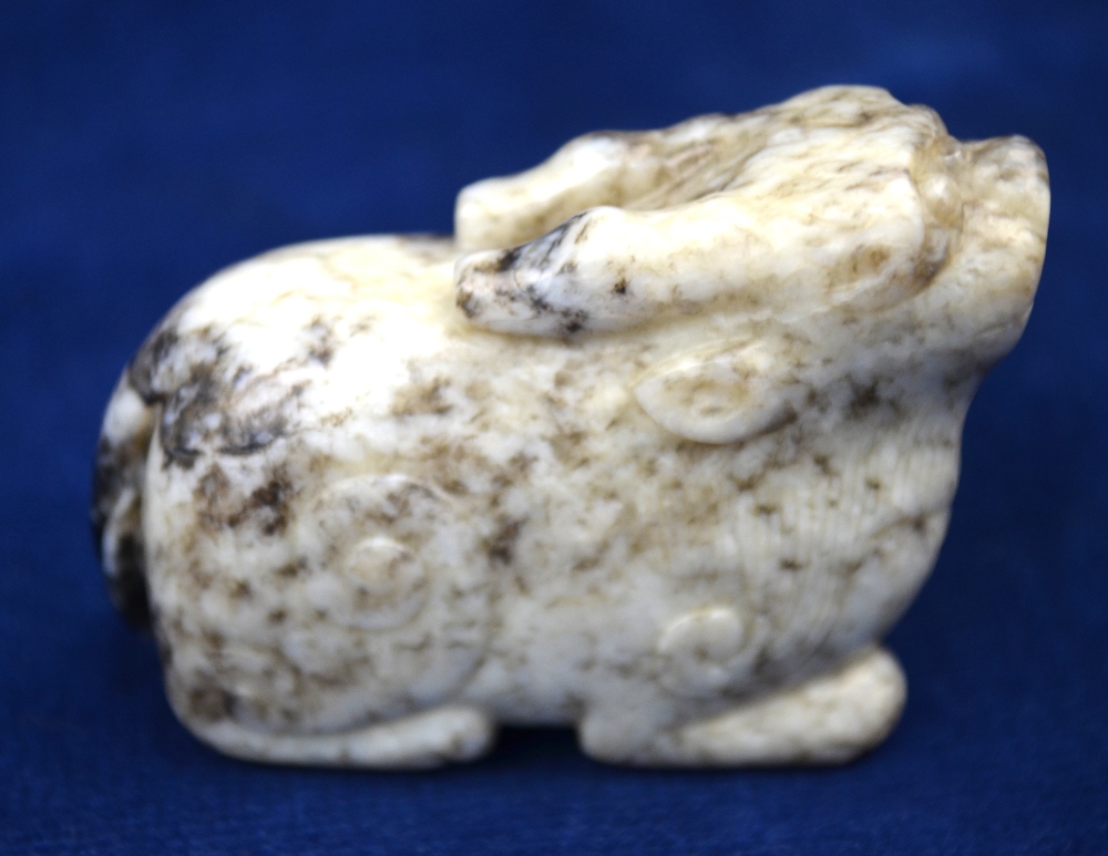 A mottled grey/white jade carved as a mythological animal,