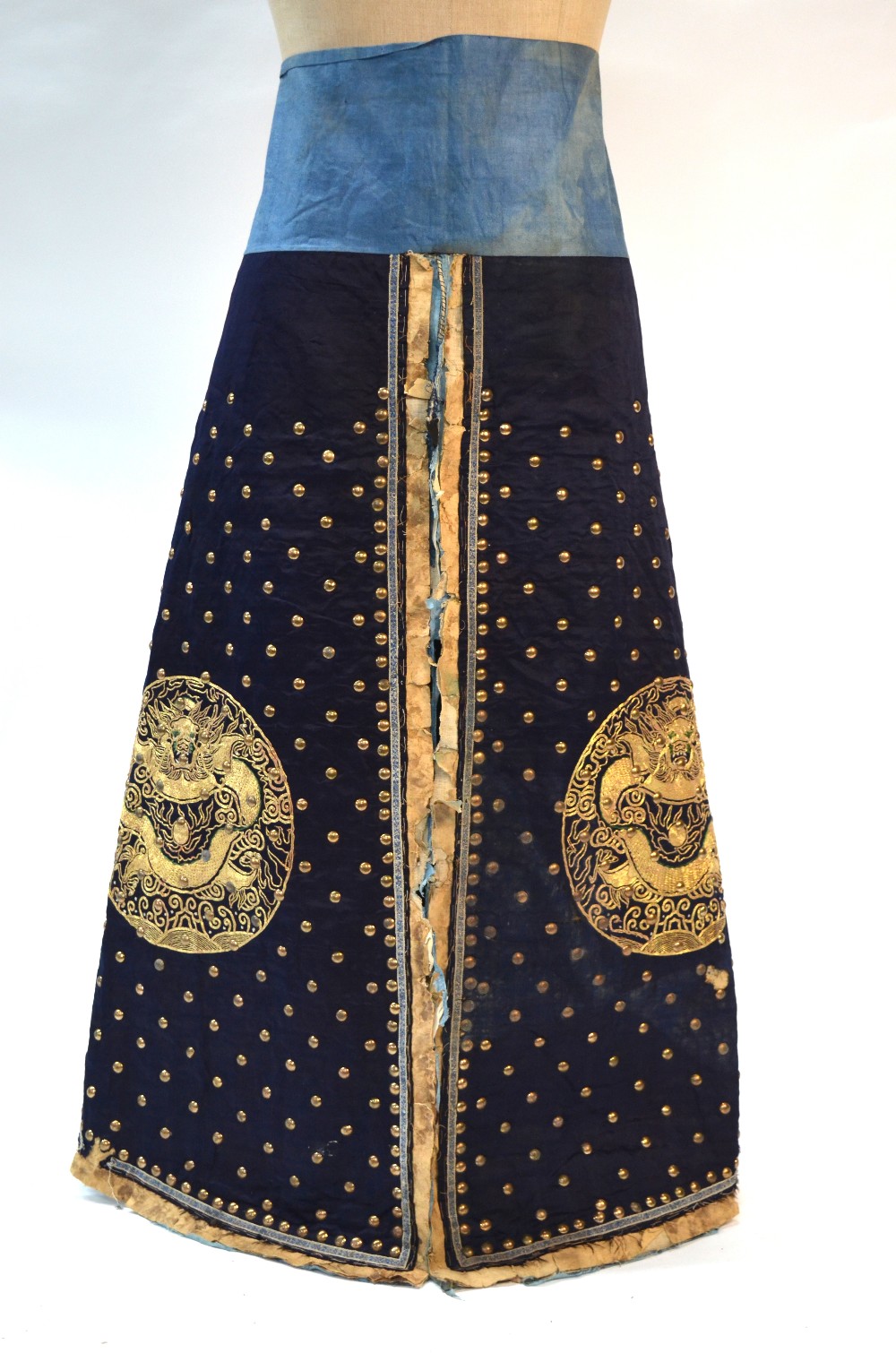 A blue-black ground leg-coat with gilt-metal studs;