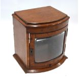 A bowfront oak smokers cabinet with bevelled glazed door and lower slide (back panel missing and