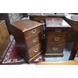 A pair of mahogany three drawer cabinets with flush brass pulls, on plinth bases,