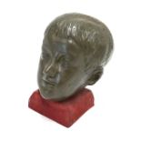 A green painted composite sculpted head of a young boy,