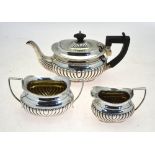 An Edwardian silver half-reeded three-piece bachelor tea service, William Devenport,