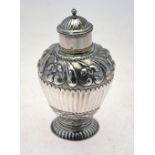 An 18th century Dutch ovoid tea caddy with embossed and chased floral decoration and half-reeding