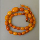 A single row of graduated pressed amber beads of mixed shades, approx 19.