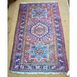 Old Persian Heriz small rug, the triple medallion design on mid-red ground,