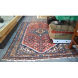 An old Persian Behbahan rug, the centre medallion on red panel ground,