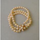 A three row uniform cultured pearl bracelet on cultured pearl cluster snap,