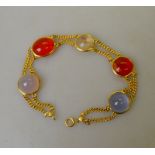 A two row yellow gold bracelet set with three pale blue cabochons and two fire opals and one water