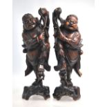 A pair of Chinese wood figures; each one possibly depicting Liu Hai with his Magical Toad,