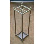 An antique brass and cast iron four-division stick stand with integral drip tray base