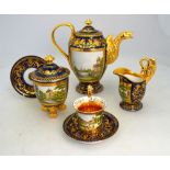 A regal tete a tete porcelain set with gilt decoration and medallions depicting the Royal Chateau