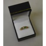 An antique diamond and emerald five stone ring with ornate floral shoulders Condition