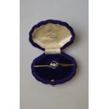 An Art Deco bar brooch set with three aquamarines in crossover style stamped 9ct,