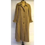 An Aquascutum lady's brown wool tweed long-length swing coat with horn buttons and two slanted