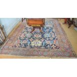 An antique Persian Heriz carpet, the all over design or geometric stylised flowers on blue ground,
