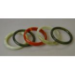 Five stone bangles including one chalcedony, two New Zealand jade,