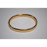 An oval hollow hinged bangle, yellow gold stamped 15ct,