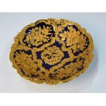 A Meissen circular dish, cobalt blue ground with gilt moulded floral and foliate decoration,