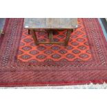 A Turkoman carpet red/brown ground with stylised gul design overall, 3.