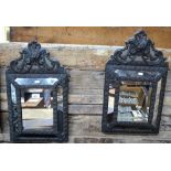 A pair of Dutch pressed brass framed cushion edged wall mirrors with decorative arched pediments,