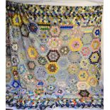 A vintage 1950s/60s hand-sewn hexagonal patchwork quilt,