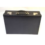 A dark navy blue textured leather suitcase with fitted interior and moire fabric lining,