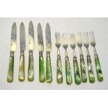An Edwardian part set of six dessert forks and five knives with green-dyed mother-of-pearl handles,
