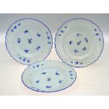 Three Meissen plates with reticulated borders painted with blue floral sprigs,