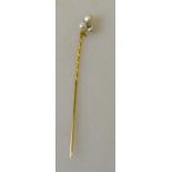 A diamond and small pearl set yellow metal stick pin in the form of a shamrock