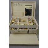 A cream multi-sectioned jewel box containing a quantity of fashion and costume jewellery including