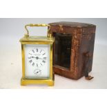 An English brass carriage clock with alarm movement (lacks bell) and enamel dial,